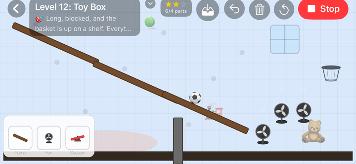 Level 12, Toy Box: a long wooden ramp running the width of the screen with a football rolling down it, a row of fans and a teddy bear on the right, and the basket up on a shelf above them.