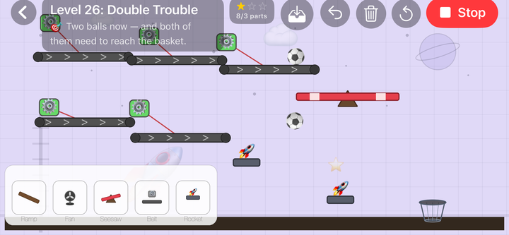 Level 26, Double Trouble: five conveyor belts, a seesaw and two rocket pads strung across a purple space background, with two footballs in play and one basket to get both of them into.